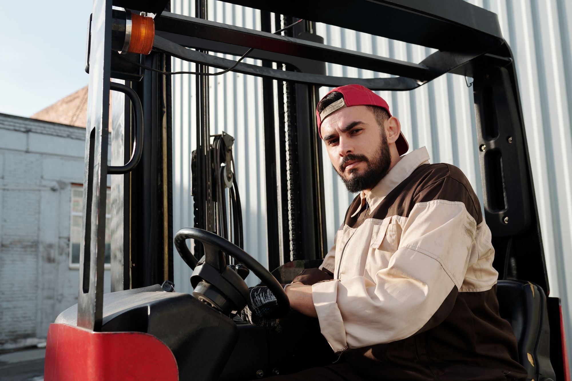 Operator seated at the controls of a forklift at an industrial site
